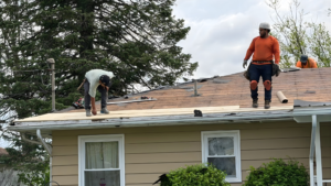 roof replacement day of install crew removing shingles and installing new roof